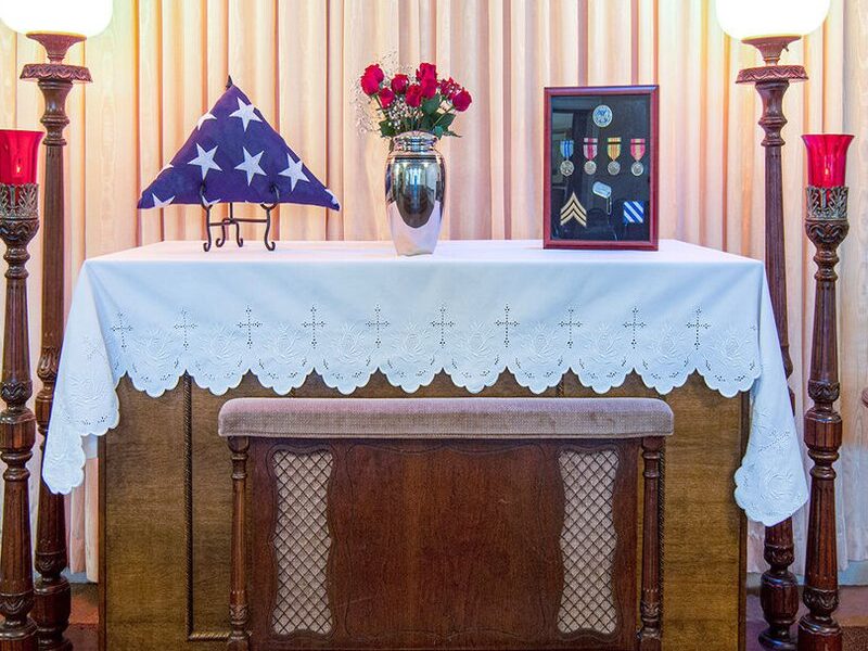A signature dedication with a folded flag and candles in the chapel